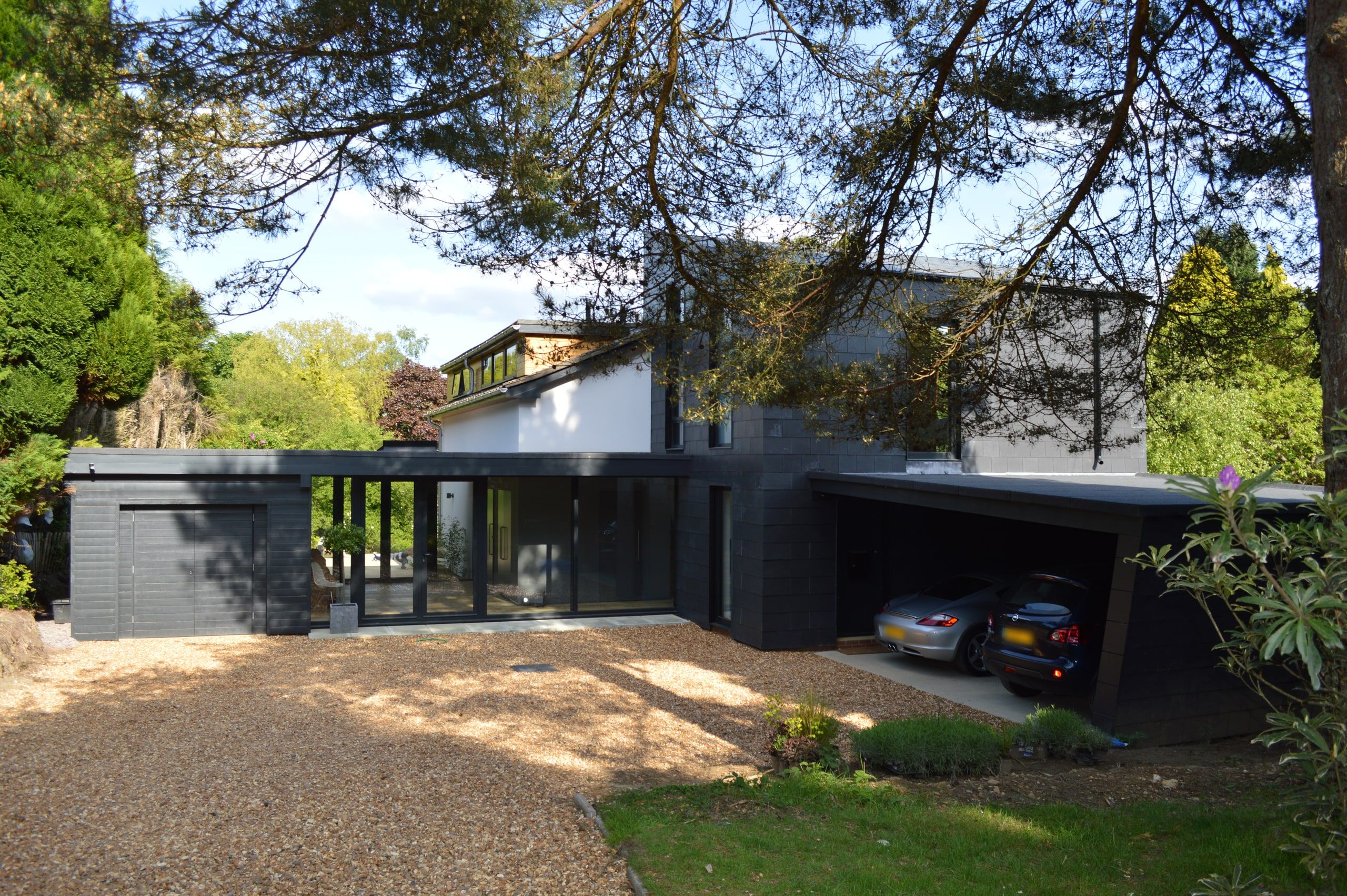 Gravel approach past a slate-clad carport to the glazed entrance hall, 1960s house, Haslemere.
