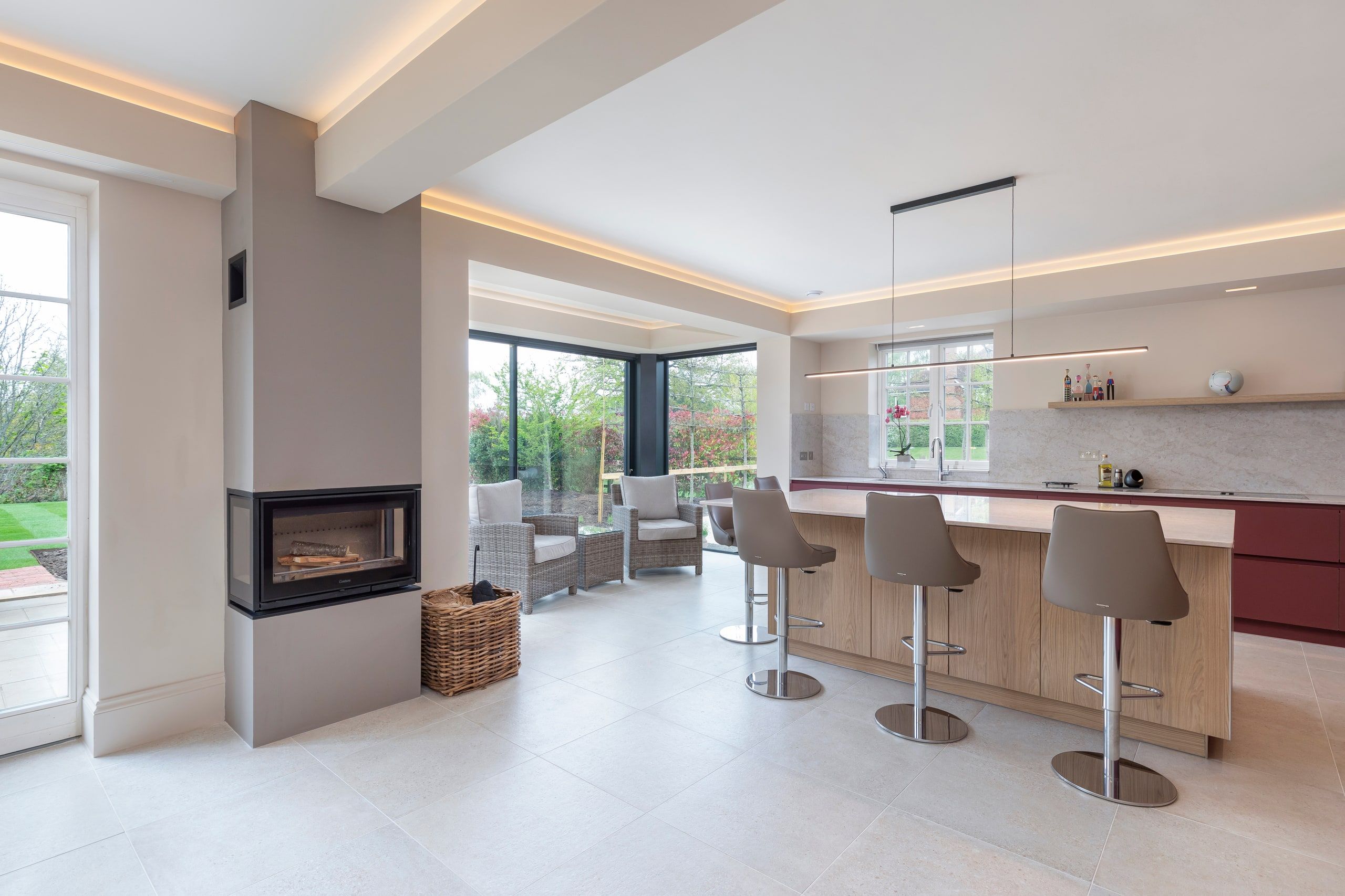 Open-plan living space with a fireplace, kitchen island and garden glazing, detached house, Shackleford.