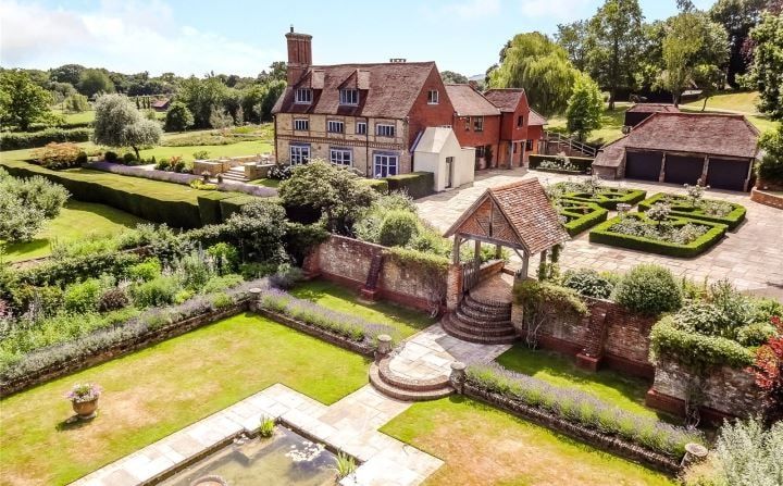 Aerial view over the house, walled gardens and formal pond in extensive grounds, Grade II listed country house, Chiddingfold.