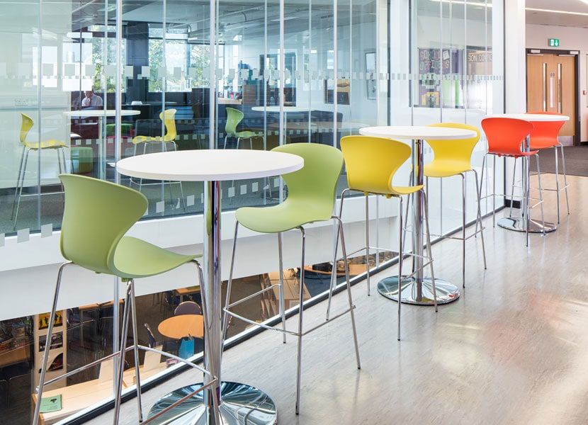 High stools and tables along the full-height glazing of the sixth form social space, St Bartholomew's School, Newbury.