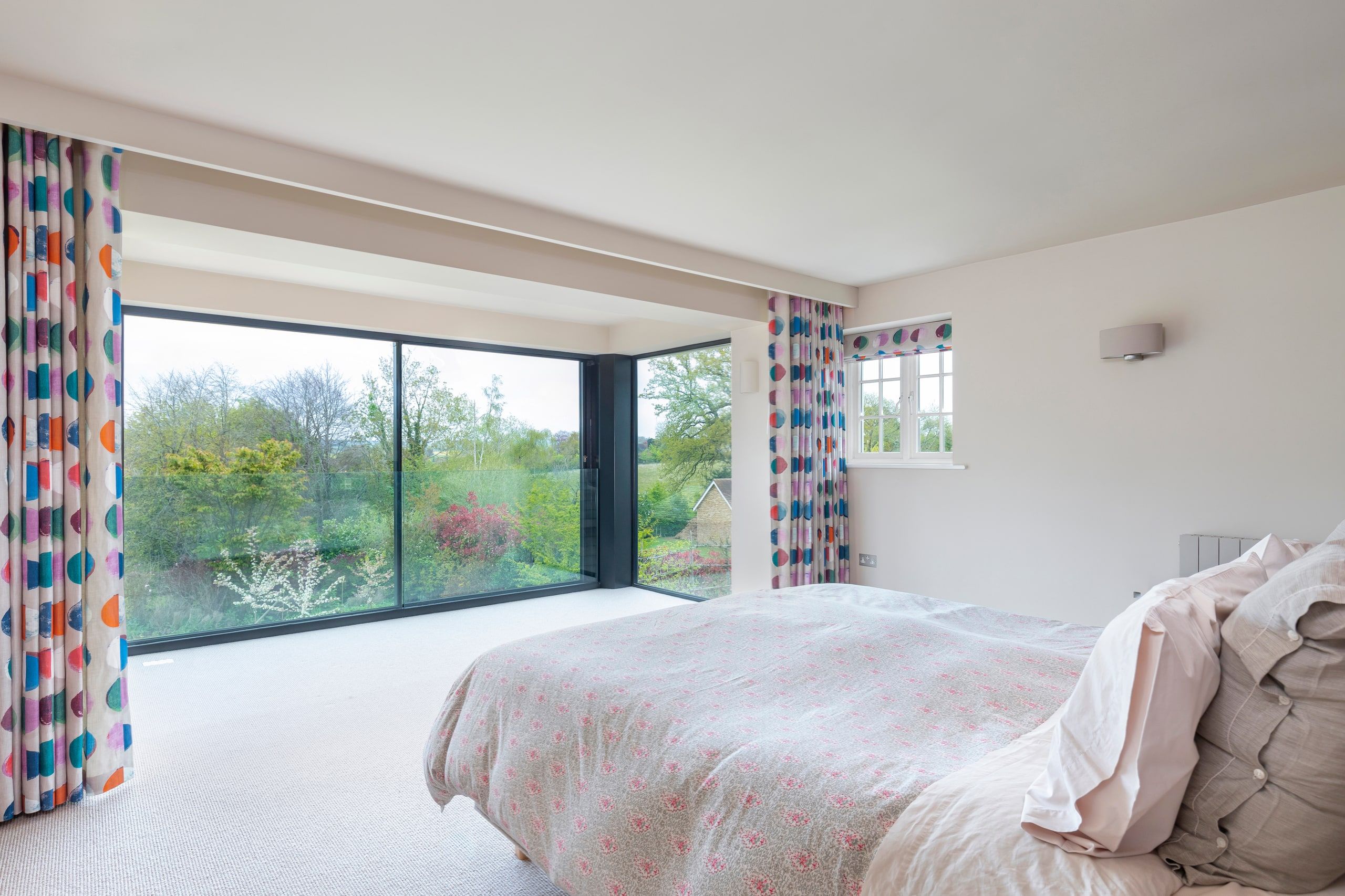 Master suite bay window with full-height glazing framing countryside views, detached house, Shackleford.