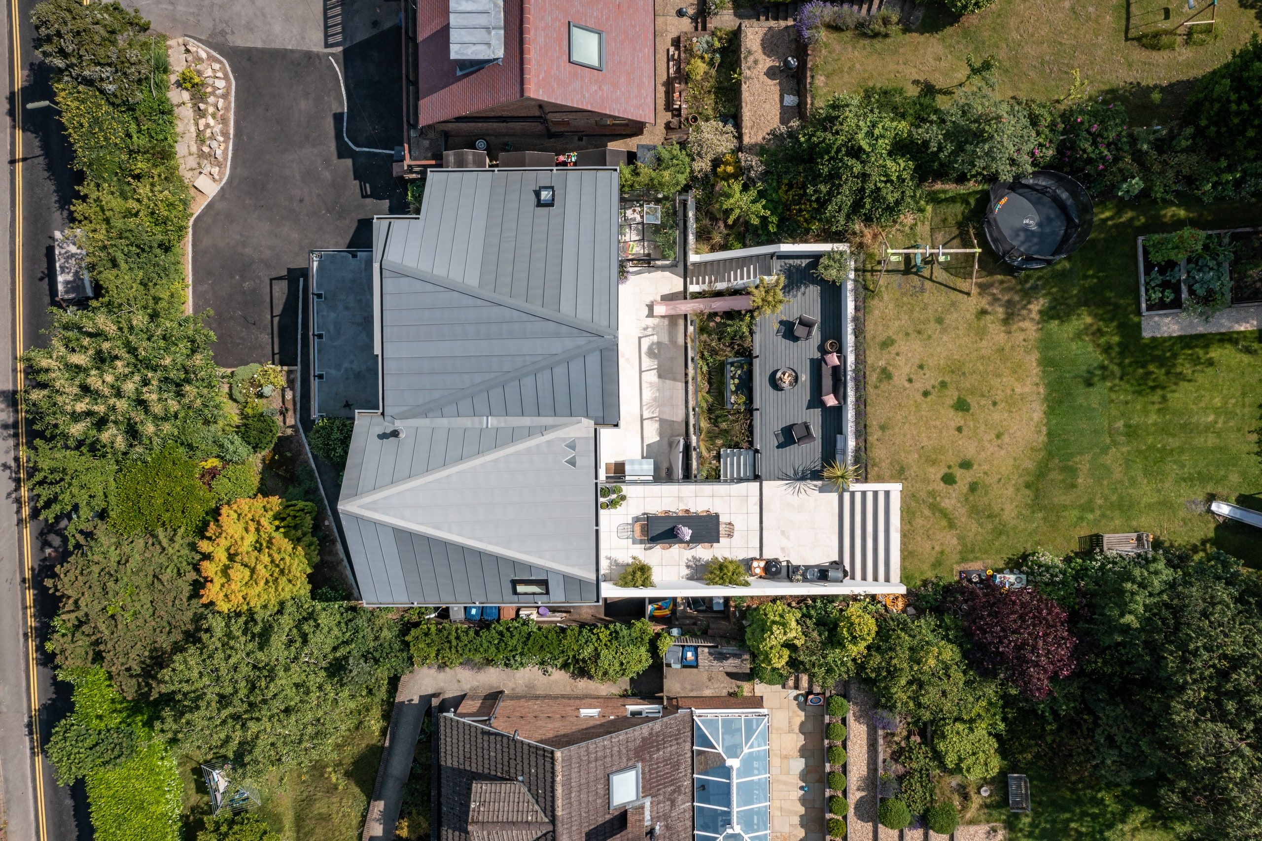 Aerial view of the zinc scissor roof and the terraces stepping down to the garden, upside down house, Haslemere.