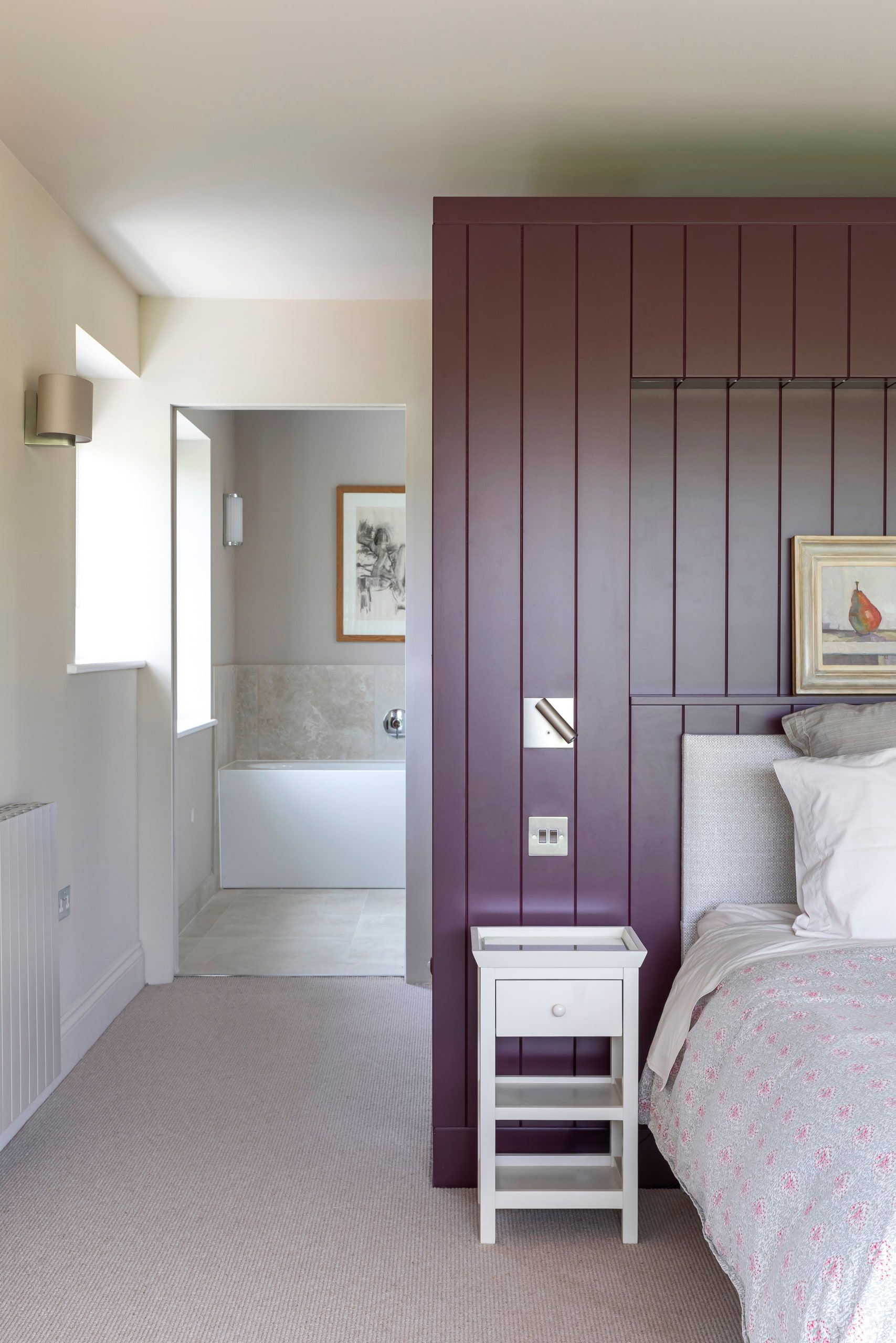 Panelled dressing wall beside the bed with the en-suite bath beyond, detached house, Shackleford.