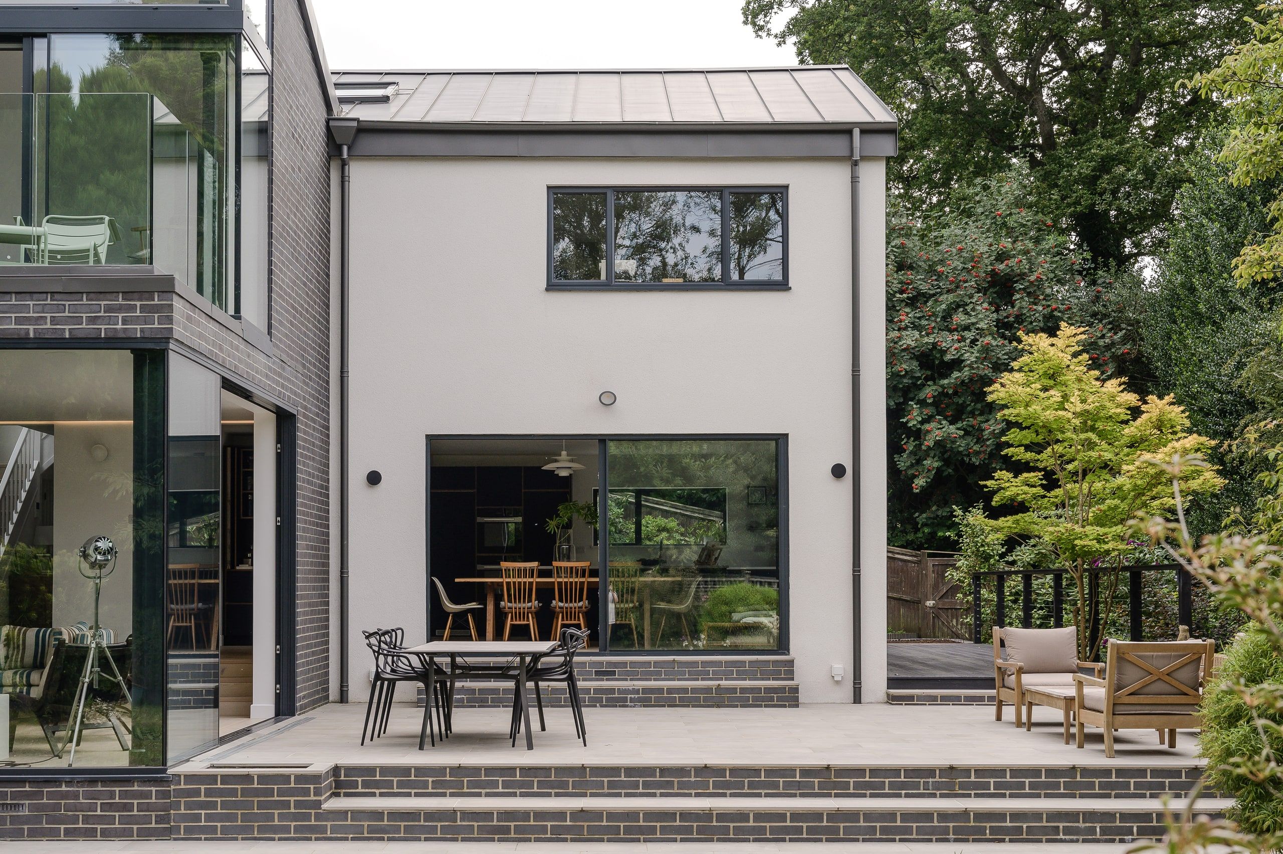Sliding doors opening from the kitchen onto a paved terrace and brick steps, 1960s house, Haslemere