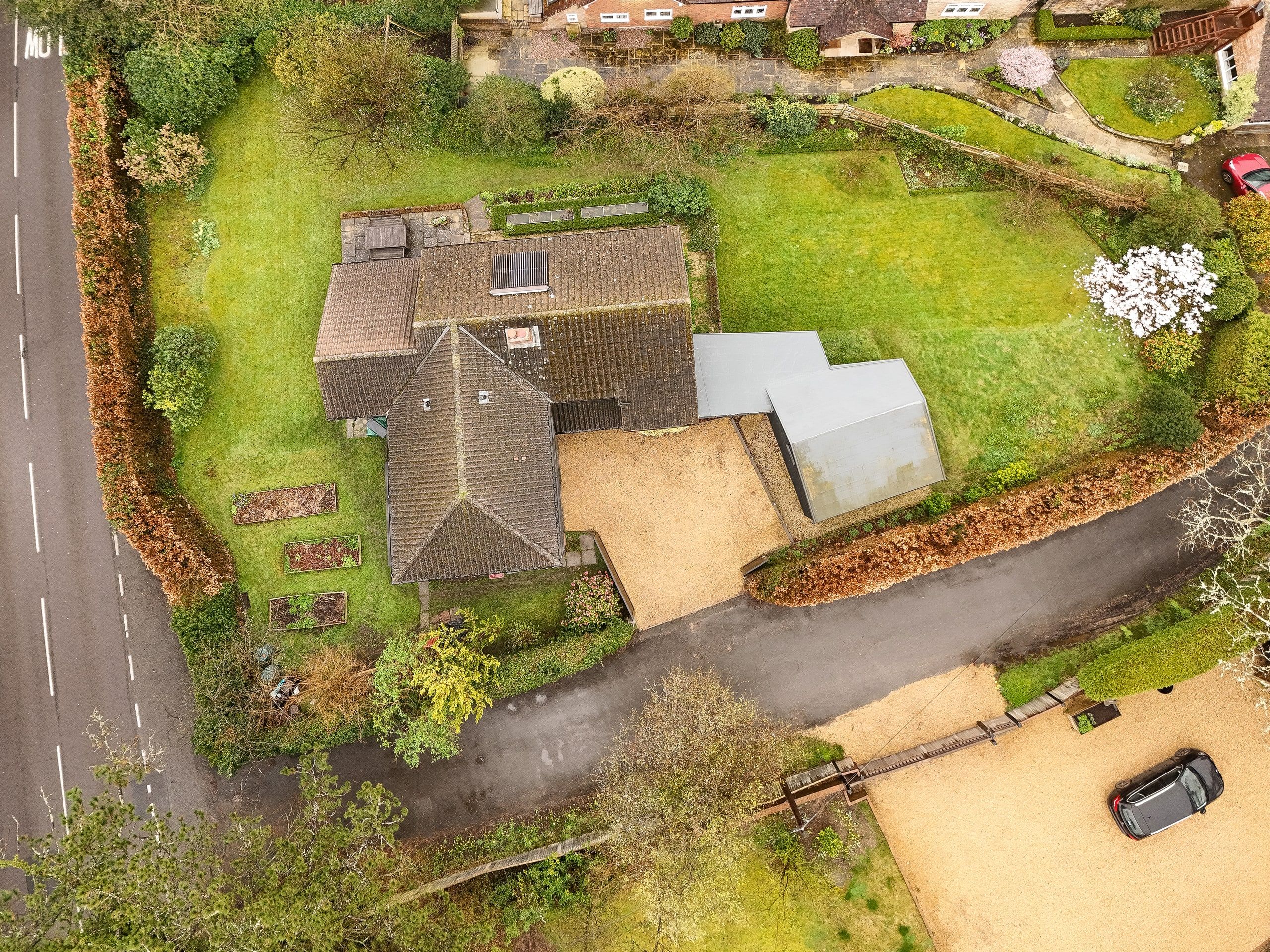 Overhead view of the house and its wooded plot beside the village lane, 1960s house, Fernhurst.